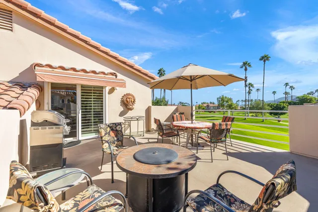 a patio with a table and chairs under an umbrella