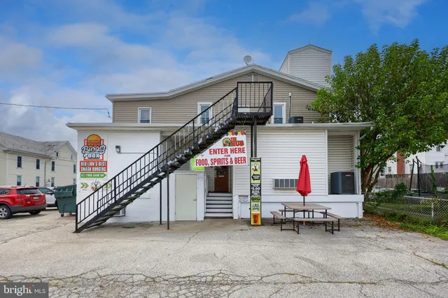 a view of a house with a patio and a yard