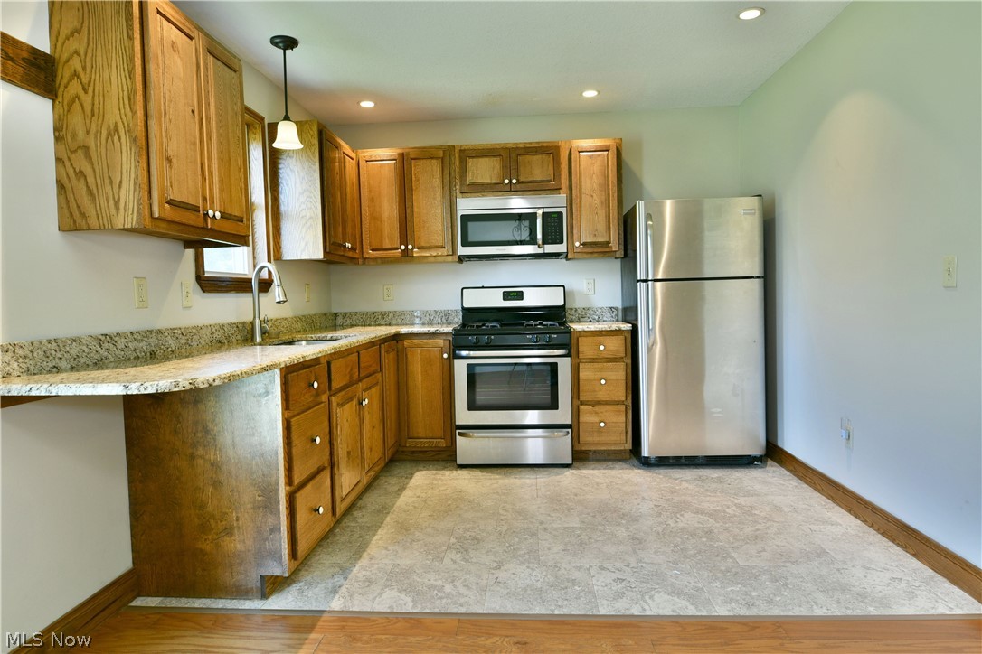 754 Warner Road Hubbard, OH 44425 - Photo 16 of 46 Kitchen featuring wood cabinetry, light-toned granite-style countertops, and stainless steel appliances