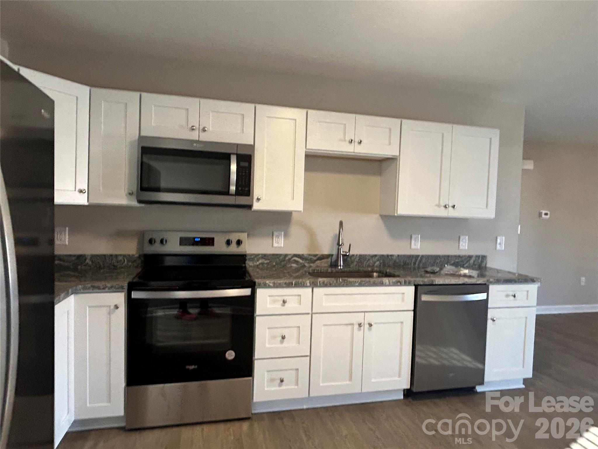 3303 Paul Elmore Road Lincolnton, NC 28092 - Photo 4 of 10 a kitchen with white cabinets and stainless steel appliances