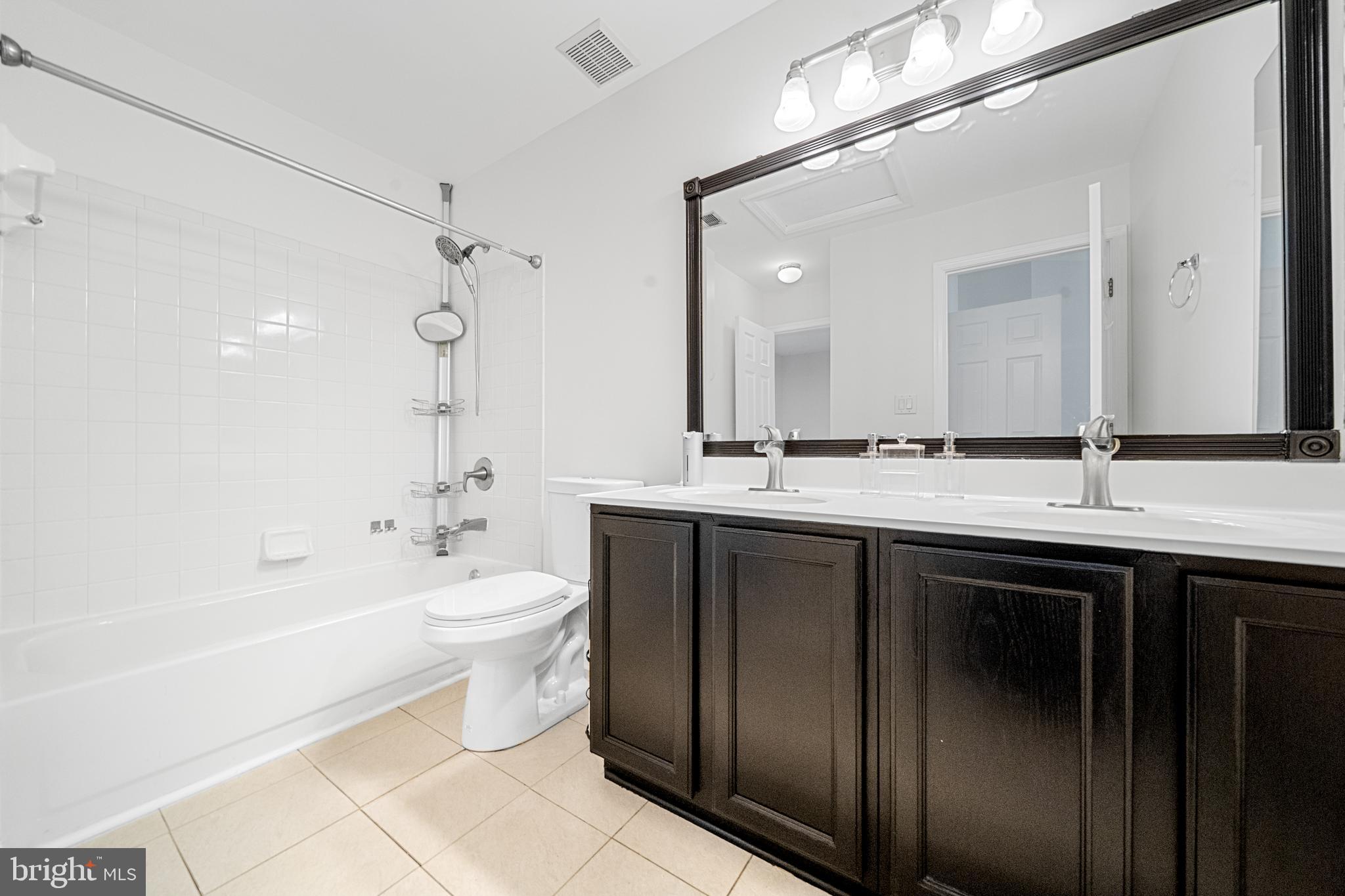 8596 Cold Harbor Loop Manassas, VA 20111 - Photo 26 of 52 a bathroom with a double vanity sink a toilet a mirror and bathtub