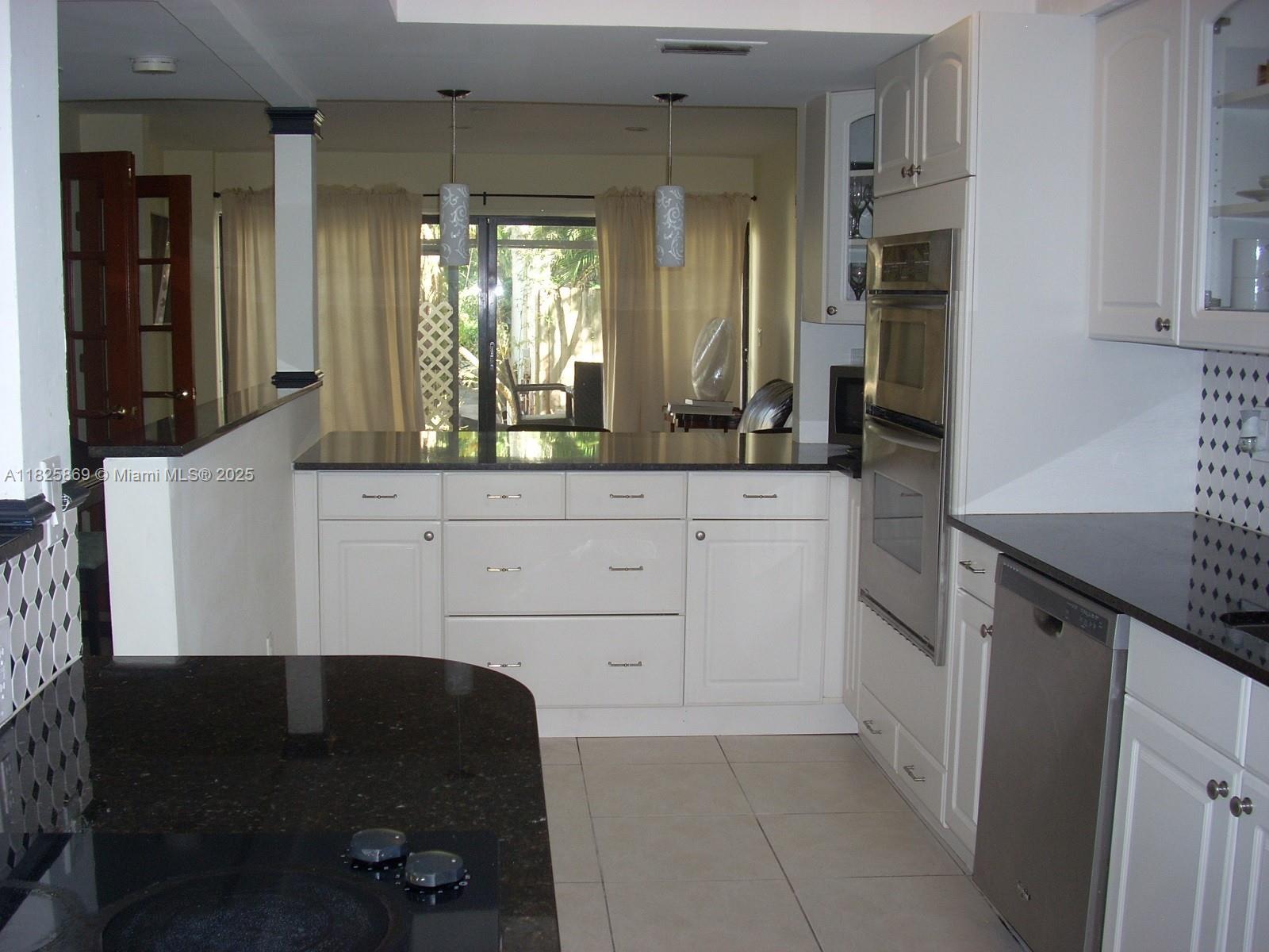Ojus Miami, FL 33180 - Photo 3 of 15 a kitchen with granite countertop white cabinets and a sink