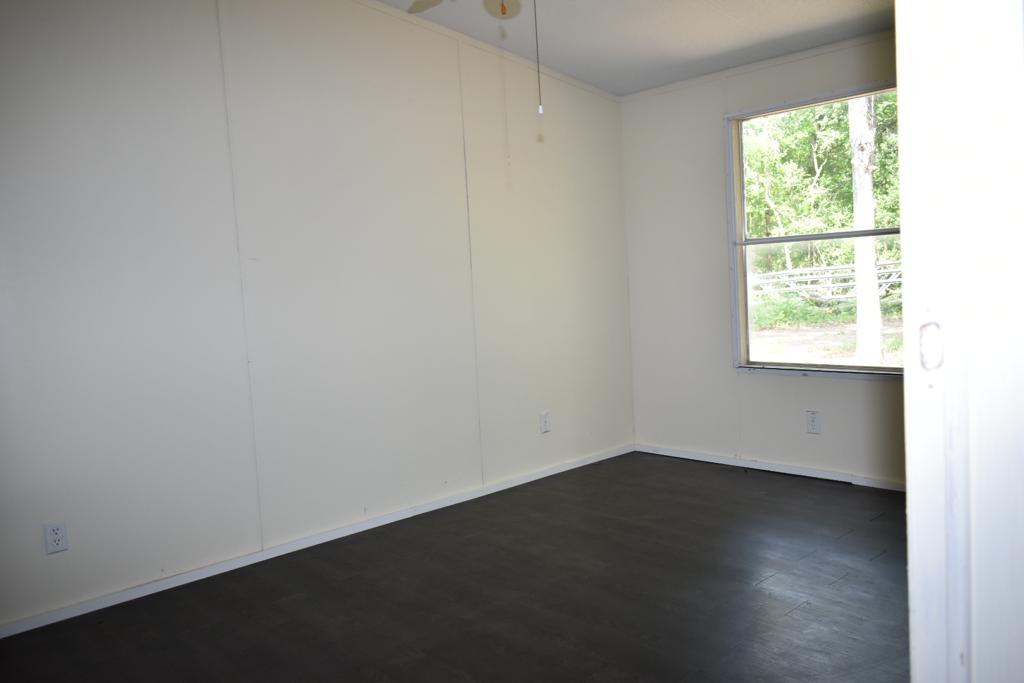 8607 Burleson Manor Road, Unit A Manor, TX 78653 - Photo 5 of 11 an empty room with wooden floor and windows