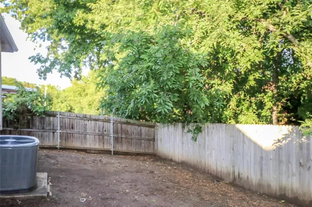 a view of a backyard with wooden fence