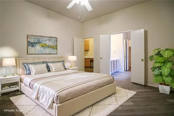 a spacious bedroom with a large bed and a potted plant