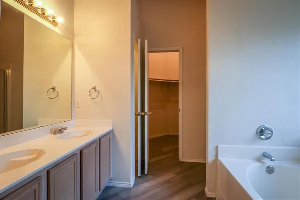 a bathroom with a tub sink and mirror