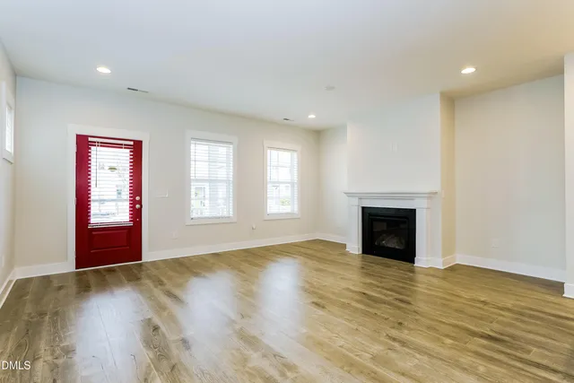 a view of empty room with wooden floor and fireplace
