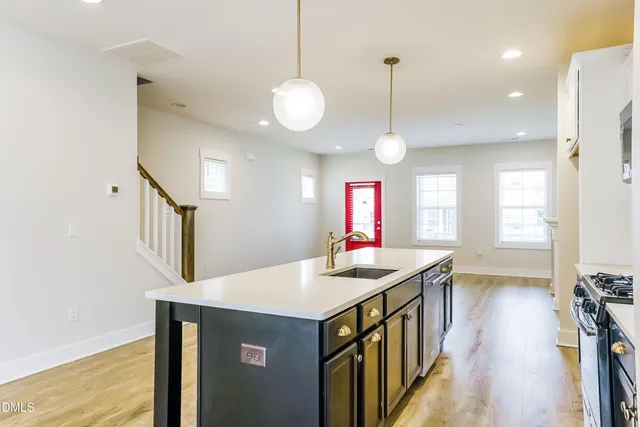 a kitchen that has a lot of cabinets and wooden floor