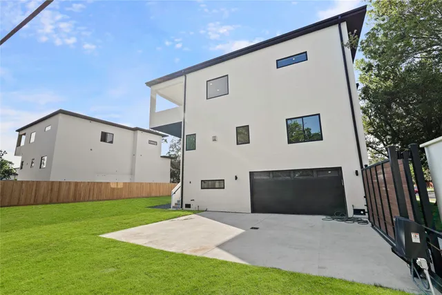 a front view of a house with a garden and trees