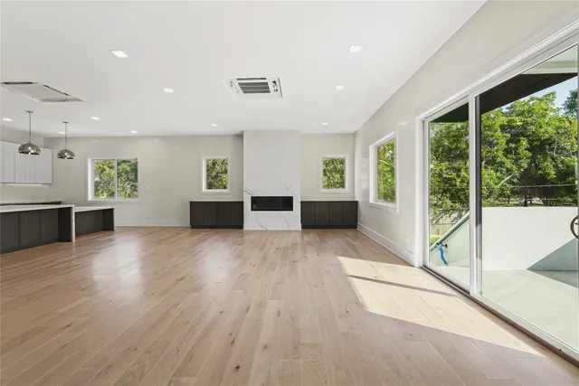 a view of empty room with wooden floor and windows