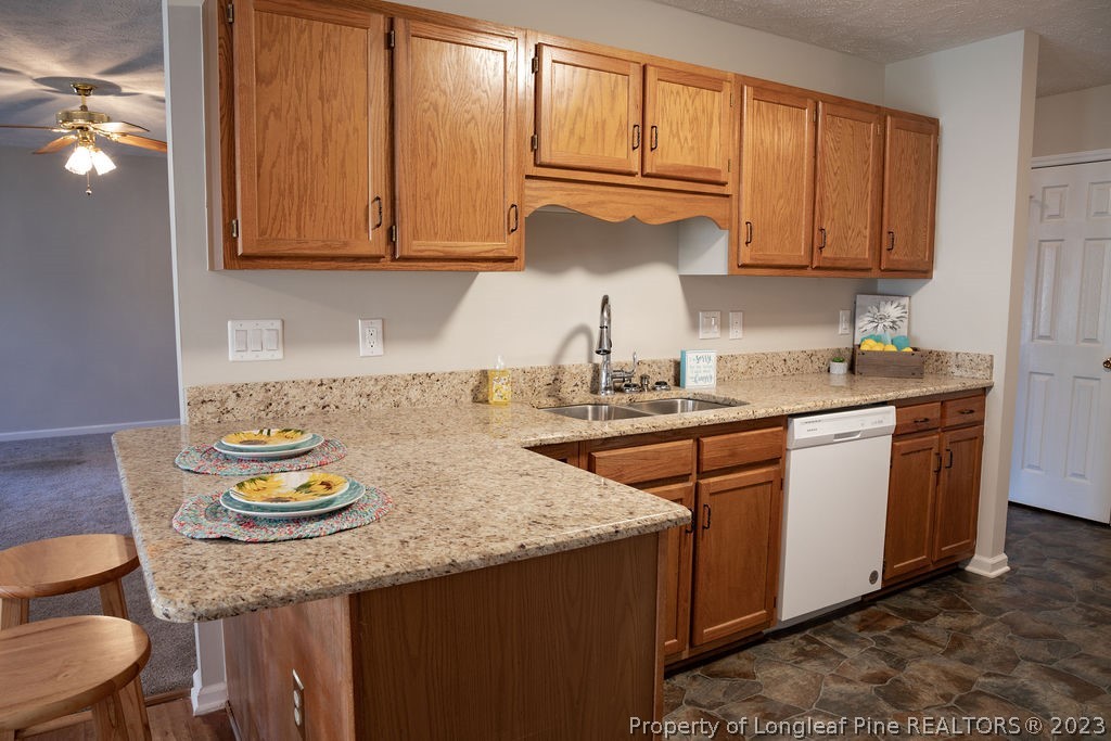 5804 Bibar Road Fayetteville, NC 28304 - Photo 13 of 37 a kitchen with stainless steel appliances granite countertop wooden cabinets a sink and dishwasher
