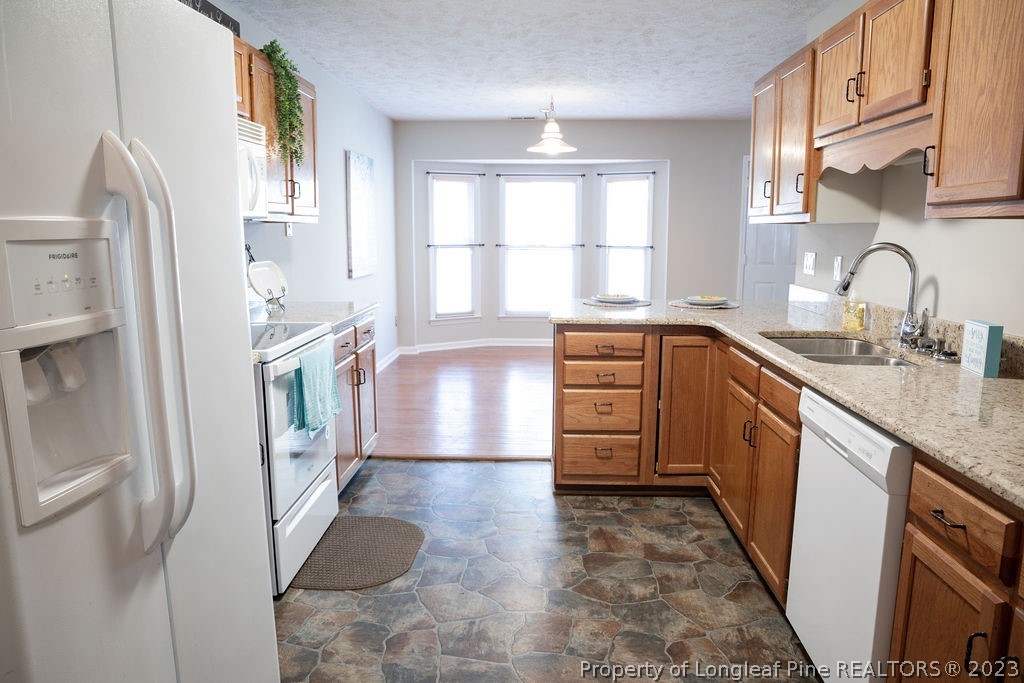 5804 Bibar Road Fayetteville, NC 28304 - Photo 14 of 37 a kitchen with stainless steel appliances a refrigerator sink and wooden cabinets