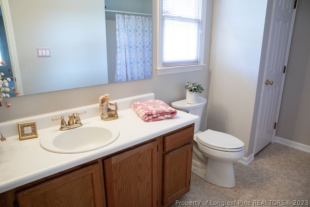 5804 Bibar Road Fayetteville, NC 28304 - Photo 25 of 37 a bathroom with a sink toilet and a mirror