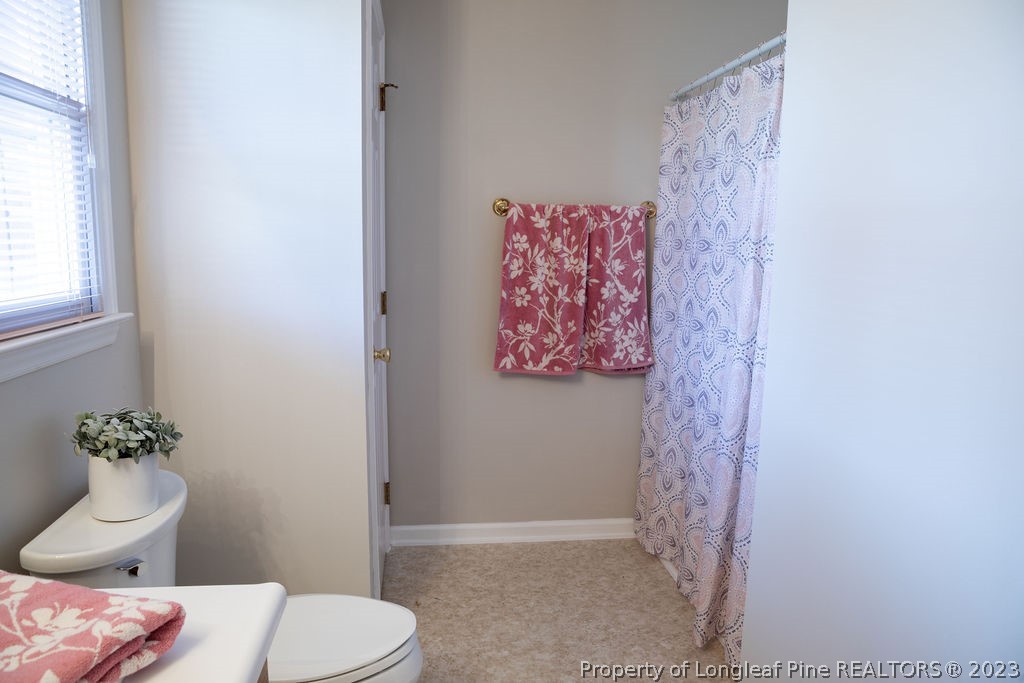 5804 Bibar Road Fayetteville, NC 28304 - Photo 26 of 37 a bathroom with a toilet and a shower curtain