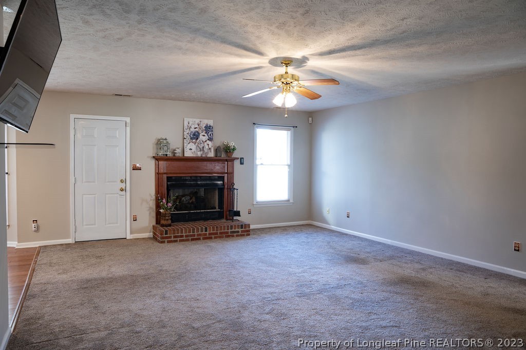 5804 Bibar Road Fayetteville, NC 28304 - Photo 4 of 37 an empty room with fireplace and fan