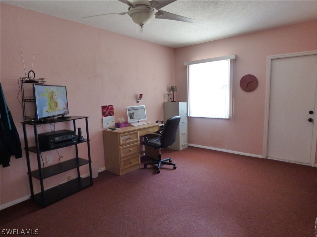 301 Davis Road Lehigh Acres, FL 33936 - Photo 28 of 29 a view of a workspace with furniture and a window