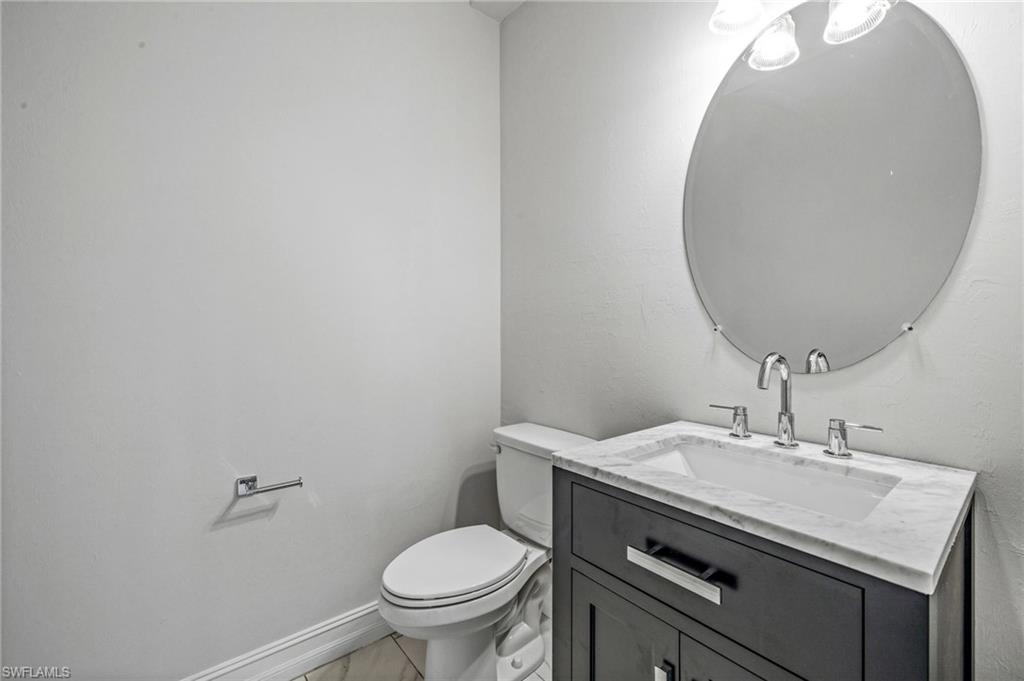 7841 Bristol Circle Naples, FL 34120 - Photo 11 of 28 a bathroom with a sink a toilet and mirror