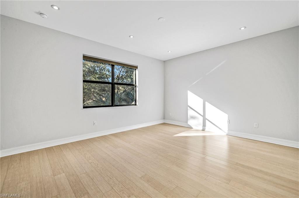 7841 Bristol Circle Naples, FL 34120 - Photo 20 of 28 an empty room with wooden floor and windows