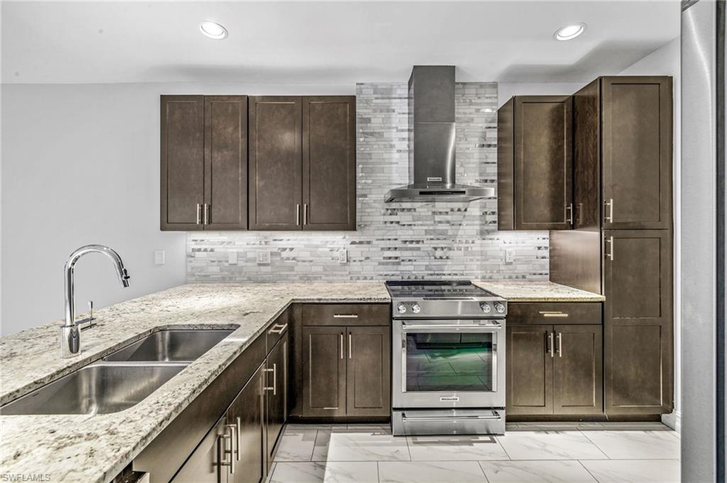 7841 Bristol Circle Naples, FL 34120 - Photo 6 of 28 a kitchen with stainless steel appliances granite countertop a sink and cabinets