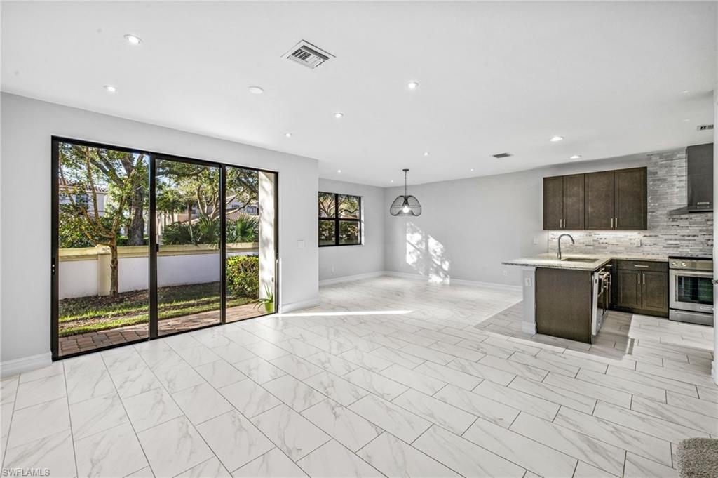 7841 Bristol Circle Naples, FL 34120 - Photo 7 of 28 a large white kitchen with a large window