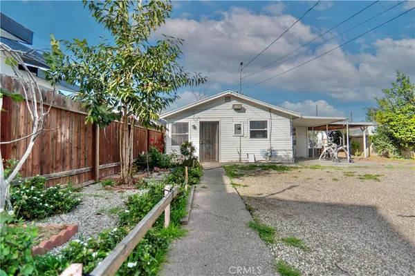 a view of a house with a yard and potted plants