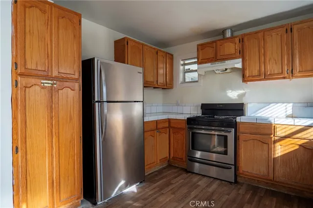 a kitchen with stainless steel appliances granite countertop a refrigerator and a stove top oven