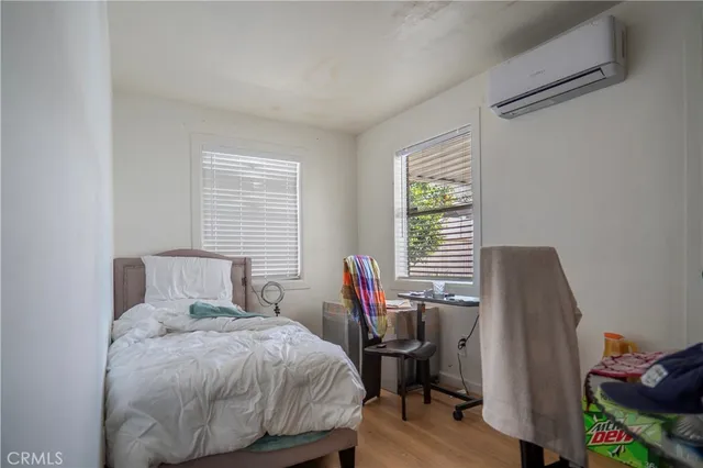 a bedroom with a bed and wooden floor