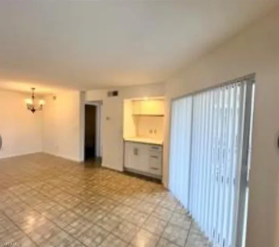 a view of an empty room with window and cabinet