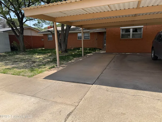 a view of a house with yard and tree