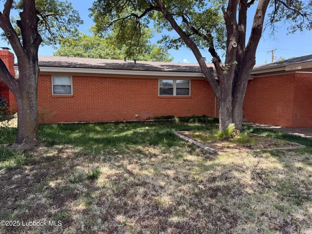 a view of a backyard with large trees