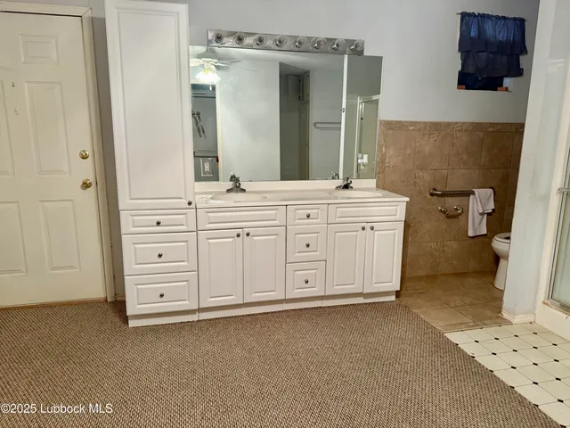 a spacious bathroom with a double vanity sink a mirror and a