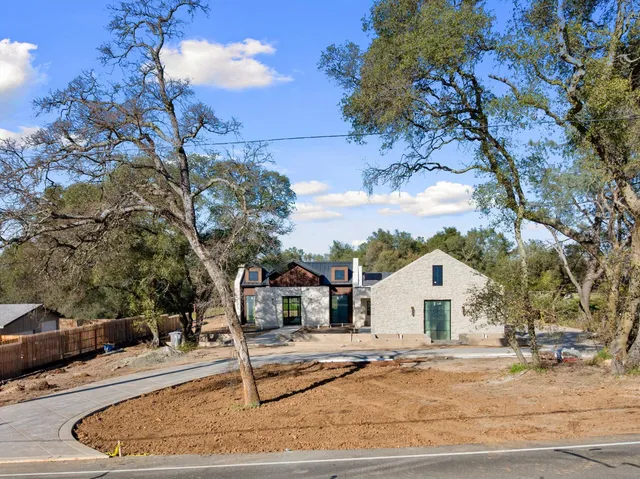 a view of white house with a yard and sitting area