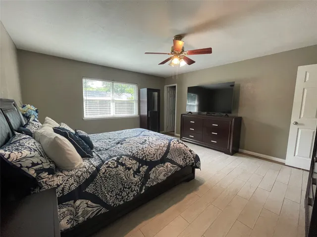 a bedroom with a bed and a flat tv screen on dresser