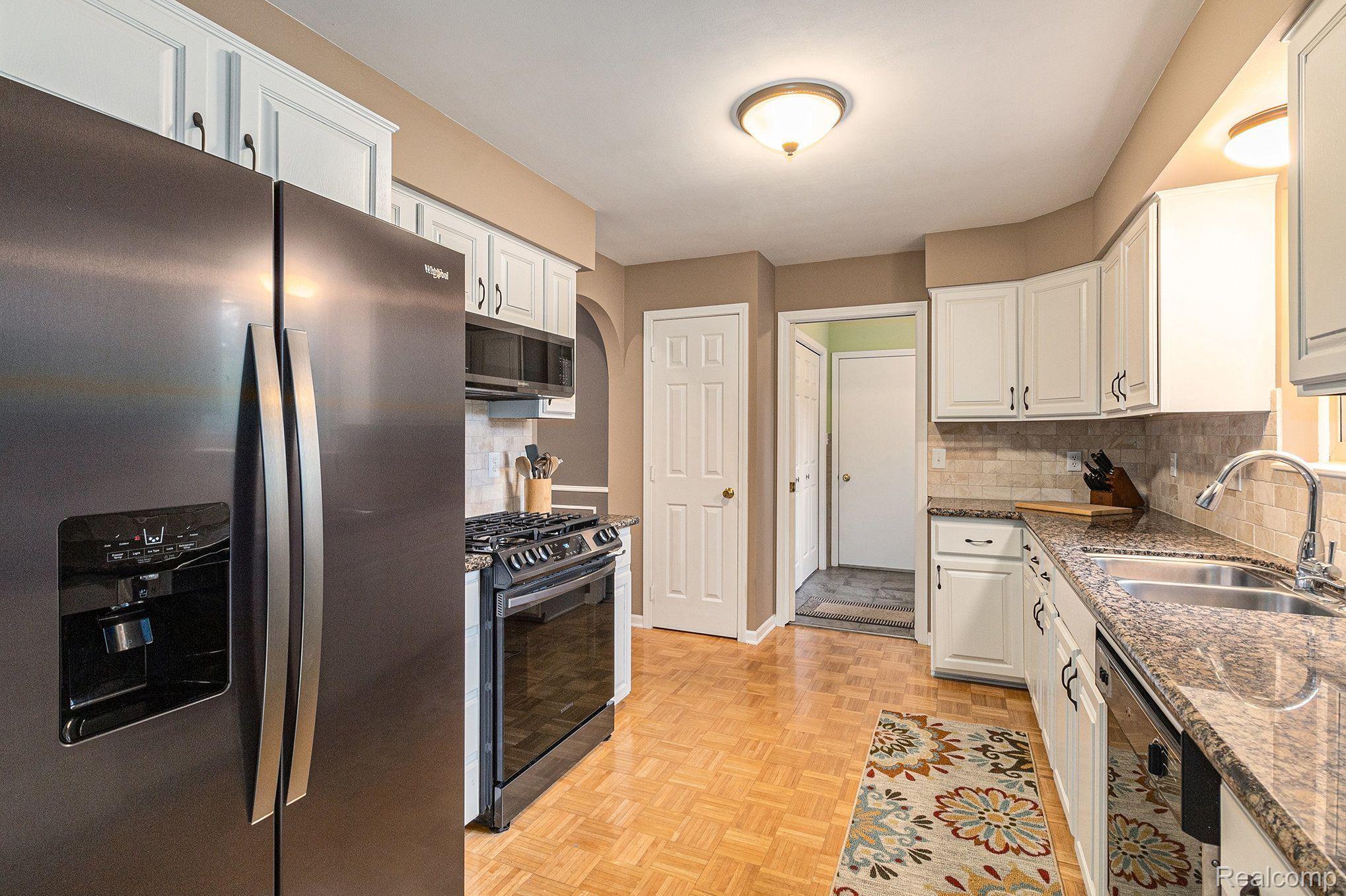 1746 Ridge Road White Lake, MI 48383 - Photo 11 of 39 Refinished Cabinets & Black Stainless Fridge/Oven