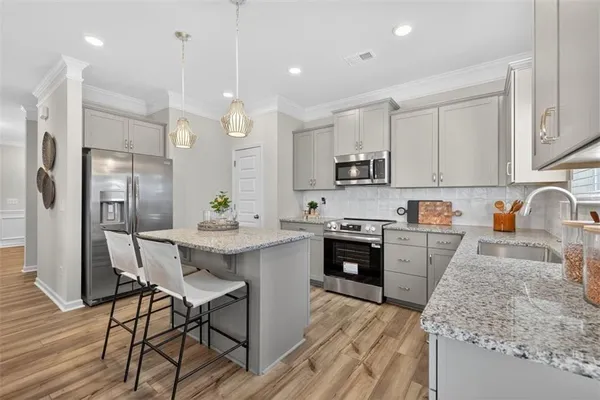 a kitchen with kitchen island white cabinets and stainless steel appliances