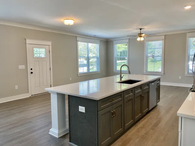 a kitchen with granite countertop a sink window and wooden floor