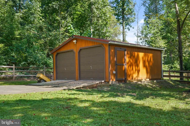a view of backyard with a barn and large trees