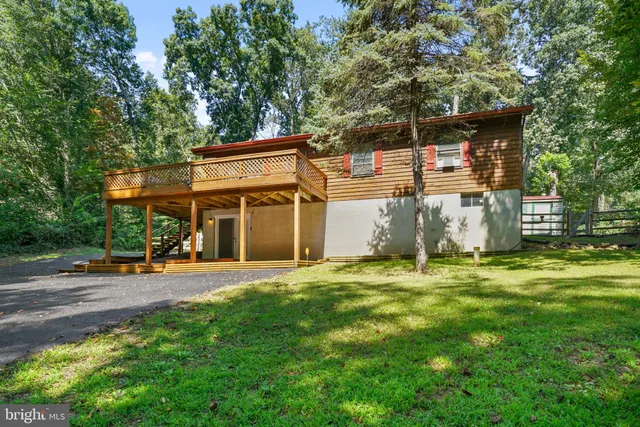 a view of a house with backyard and a tree