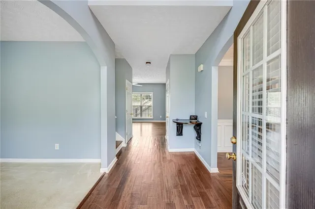 a view of a hallway with wooden floor and staircase