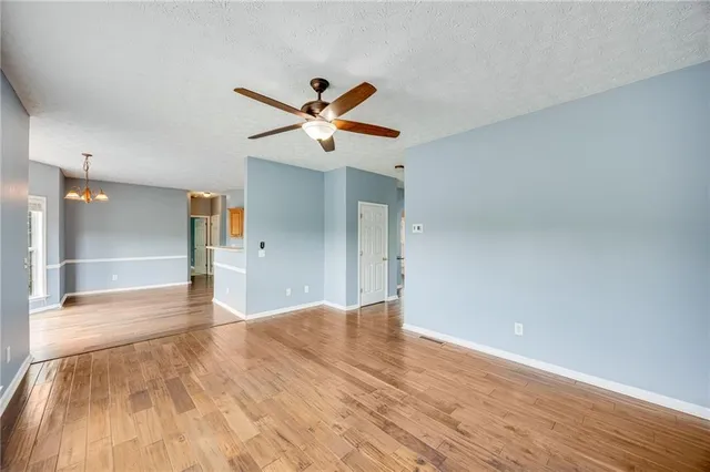 a view of a big room with wooden floor and a ceiling fan