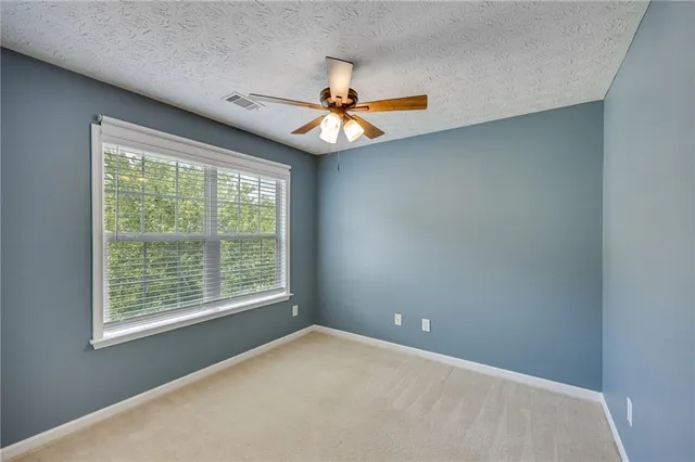 a view of a livingroom with a ceiling fan and window