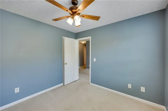 an empty room with a chandelier fan and a chandelier fan