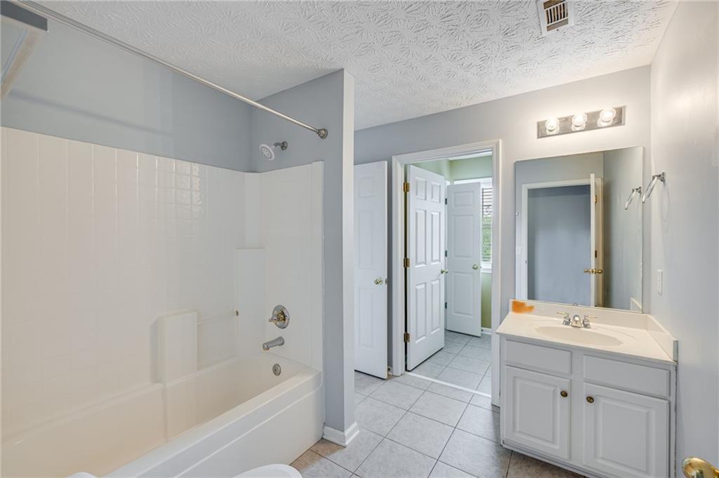 3903 Walnut Grove Way Gainesville, GA 30506 - Photo 35 of 48 a bathroom with a bathtub shower sink and mirror