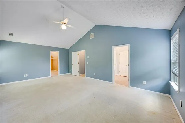 a view of an empty room with a chandelier fan