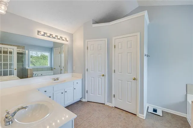 a spacious bathroom with a bathtub sink and mirror