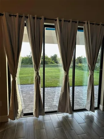 a view of backyard with floor to ceiling window and wooden fence