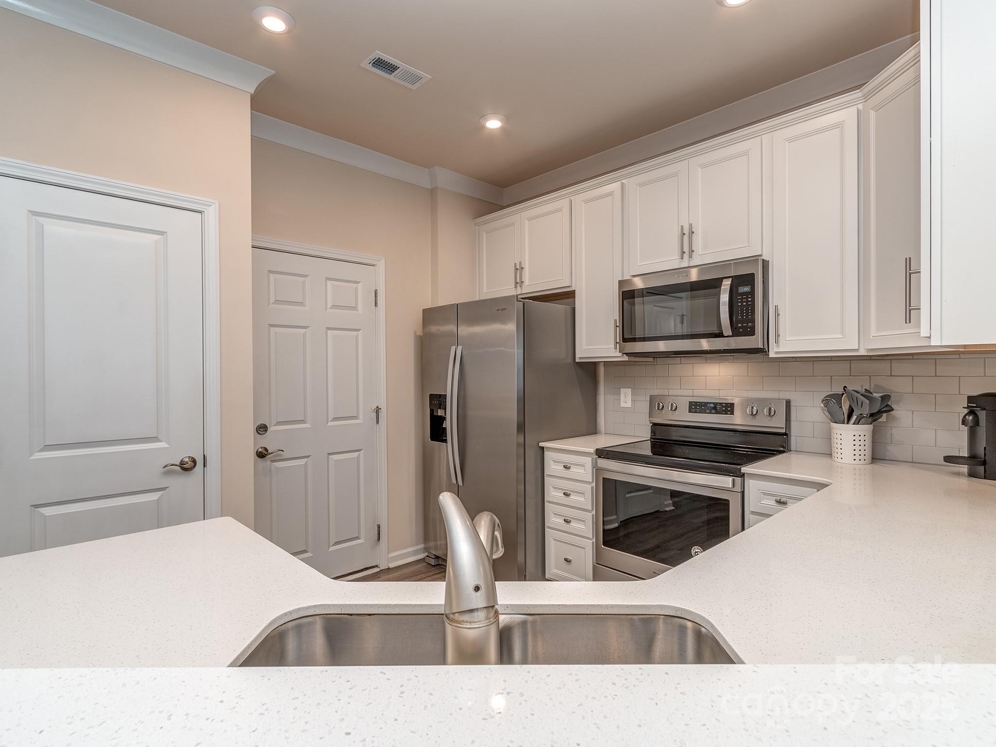 739 Elders Story Road Fort Mill, SC 29708 - Photo 8 of 30 a kitchen with stainless steel appliances kitchen island granite countertop a refrigerator and a sink