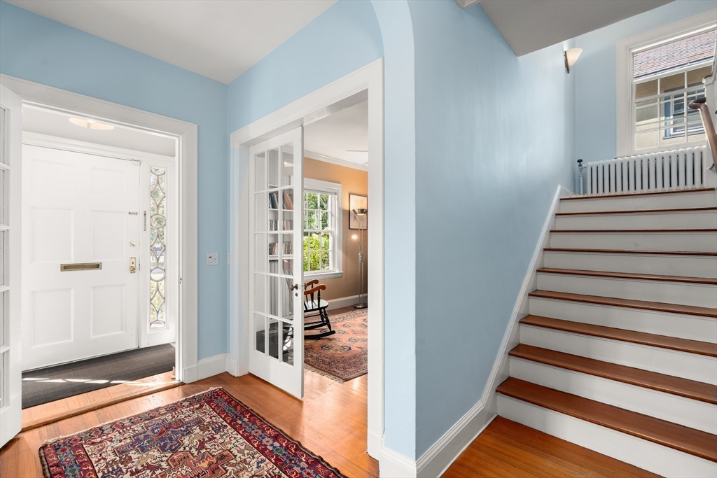 54 Arborway Boston, MA 02130 - Photo 11 of 29 a view of a hallway with wooden floor and windows