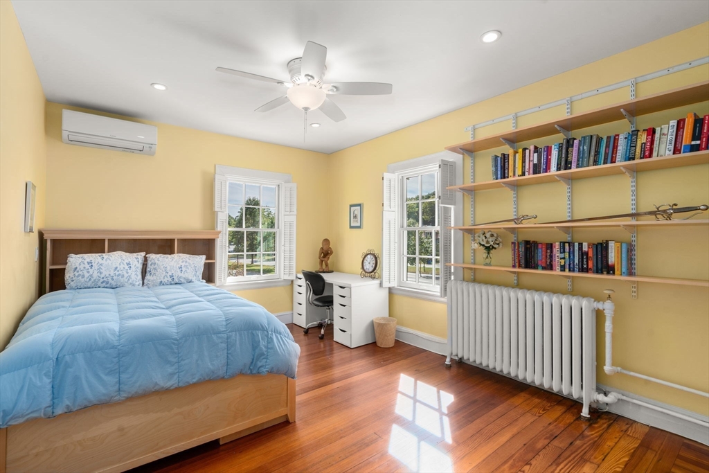 54 Arborway Boston, MA 02130 - Photo 15 of 29 a bedroom with a bed and a book shelf