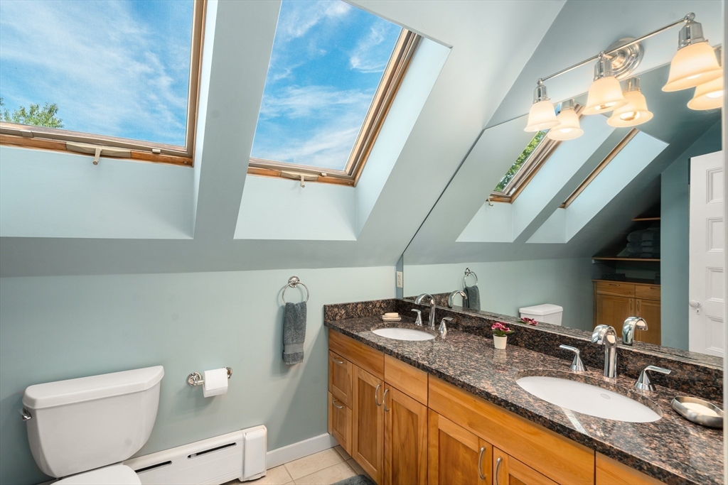 54 Arborway Boston, MA 02130 - Photo 17 of 29 a bathroom with a granite countertop sink a mirror and a toilet